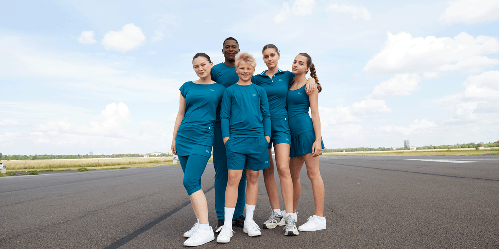 Team aus 5 Personen mit Sportkind Kleidung in petrol